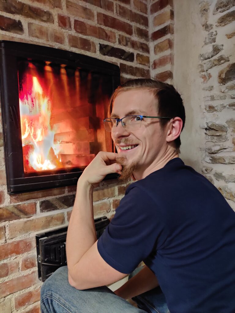 Joffrey Fouquet, artisan poêlier-fumiste, devant un foyer allumé